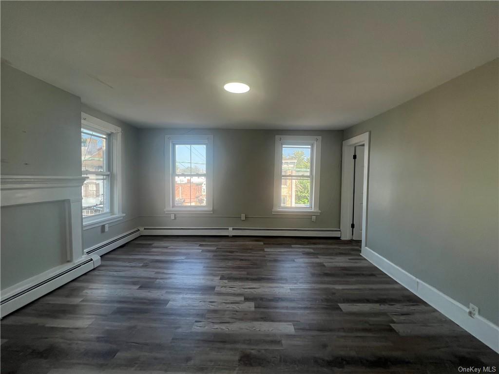 Empty room featuring dark hardwood / wood-style flooring