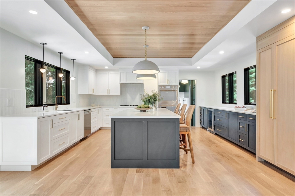 a kitchen with stainless steel appliances kitchen island hardwood floor sink stove and wooden cabinets