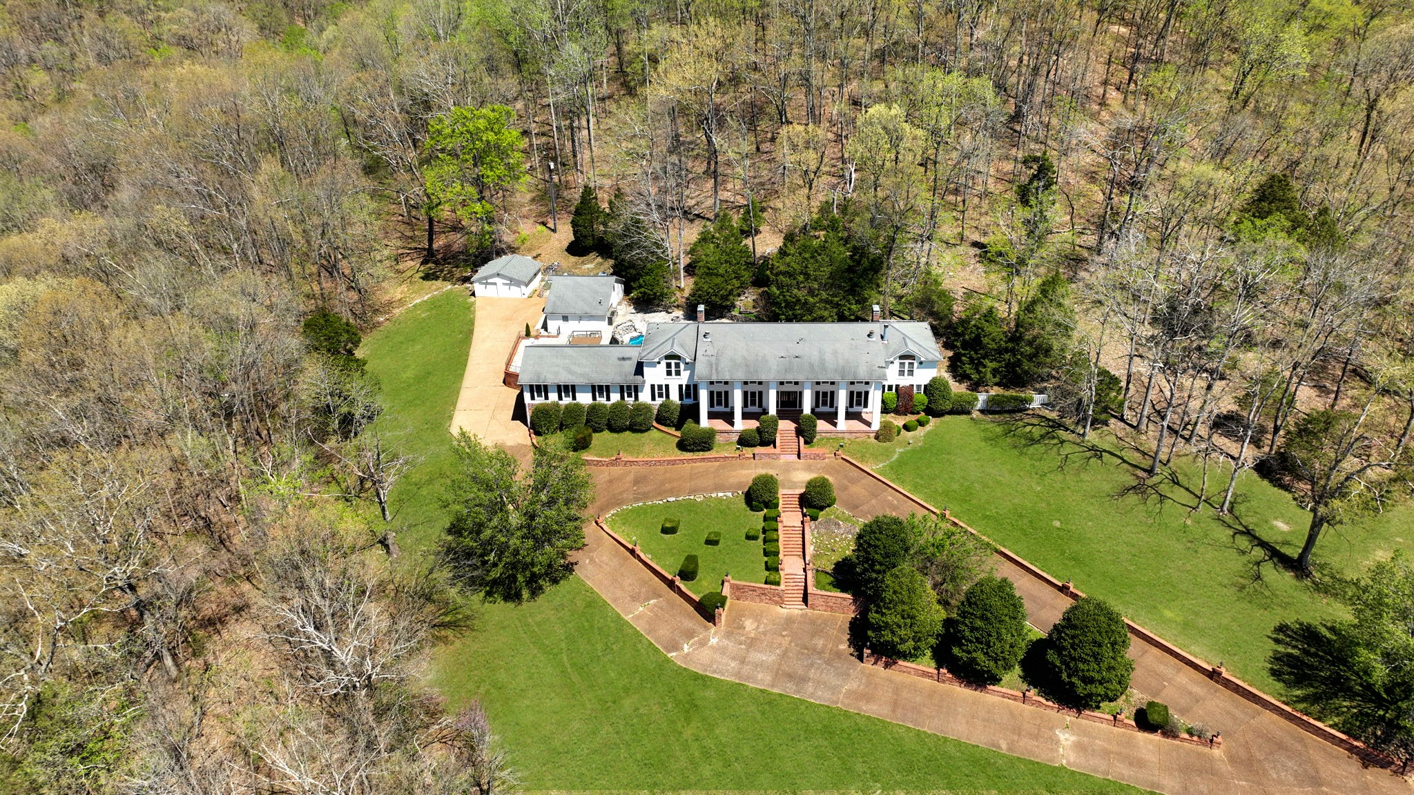 an aerial view of a house with a yard basket ball court and outdoor seating