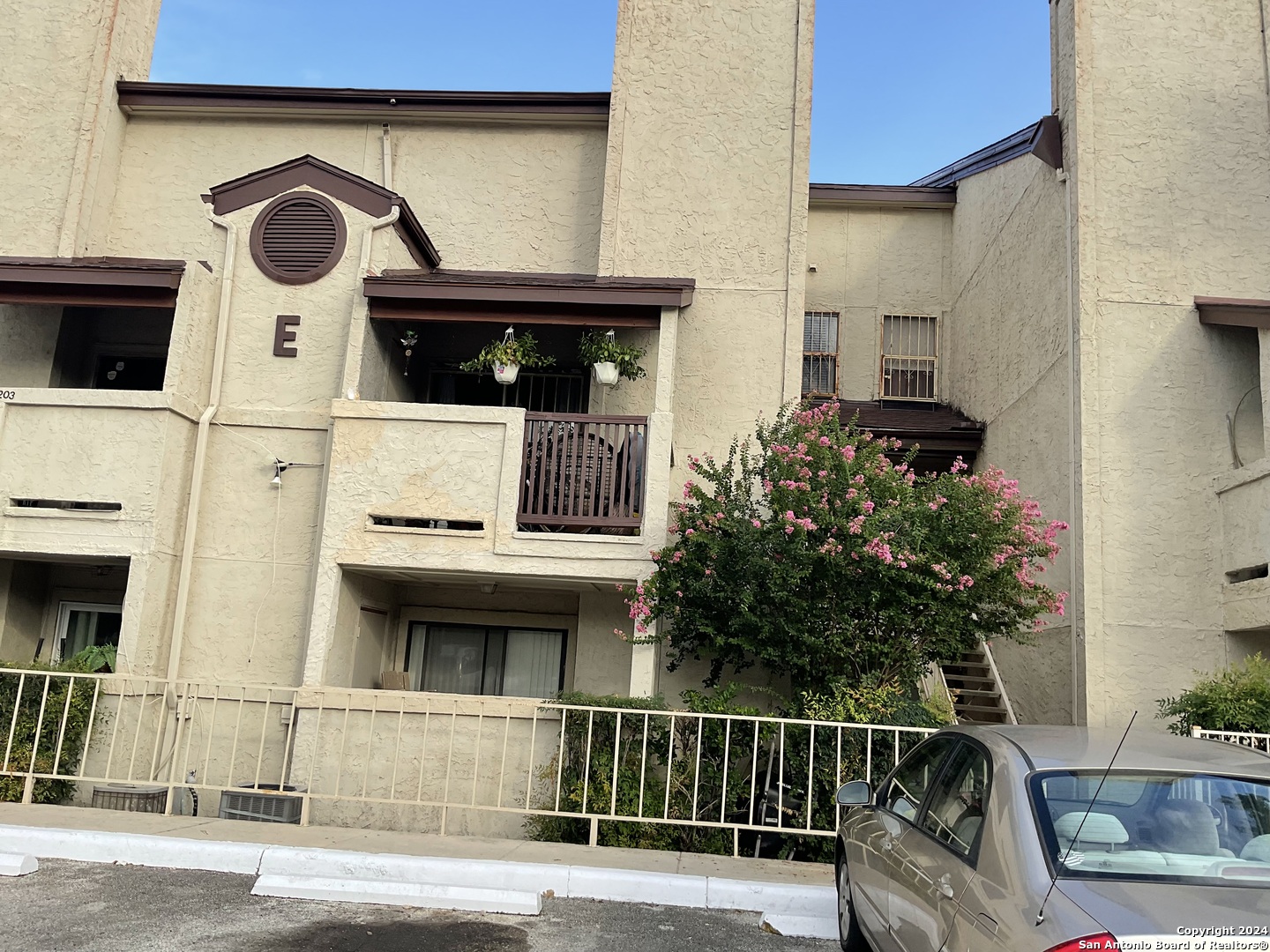 a view of a house with a cars park on side of road