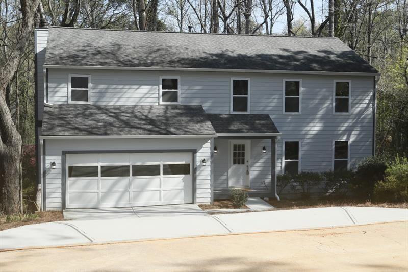 a front view of a house with a garden and garage