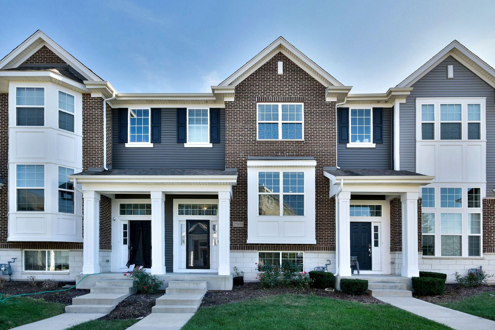 front view of a brick house with a yard