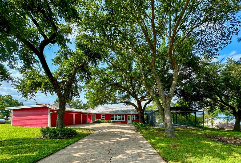 a front view of a house with garden and trees