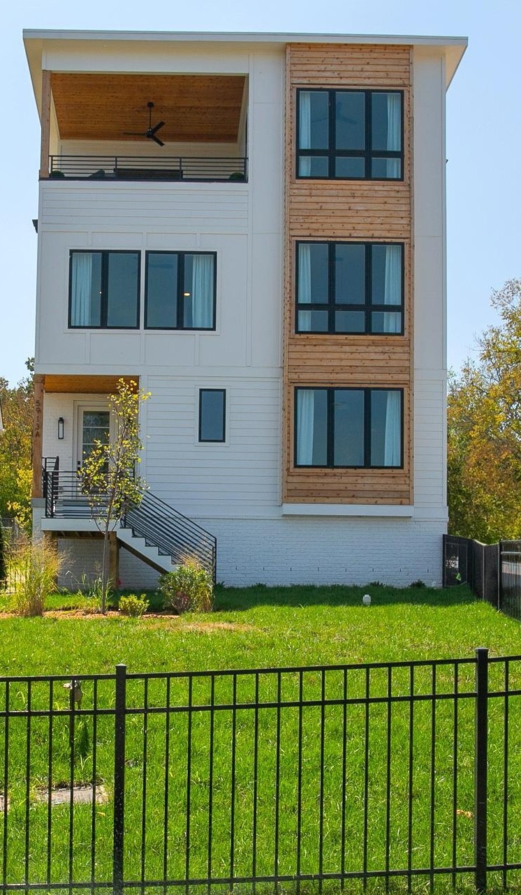 a view of a brick house with a yard and plants