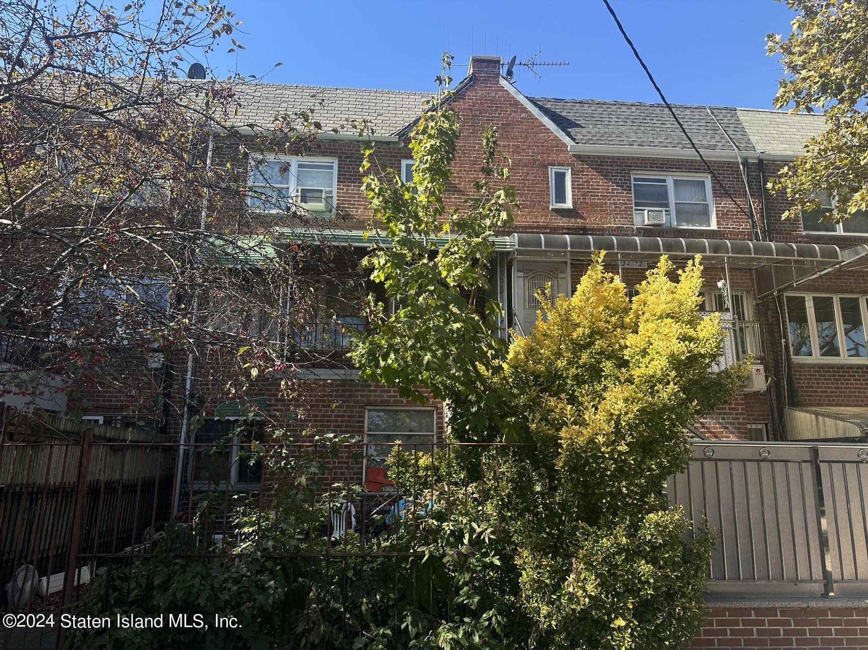 a view of a brick house with a flower garden