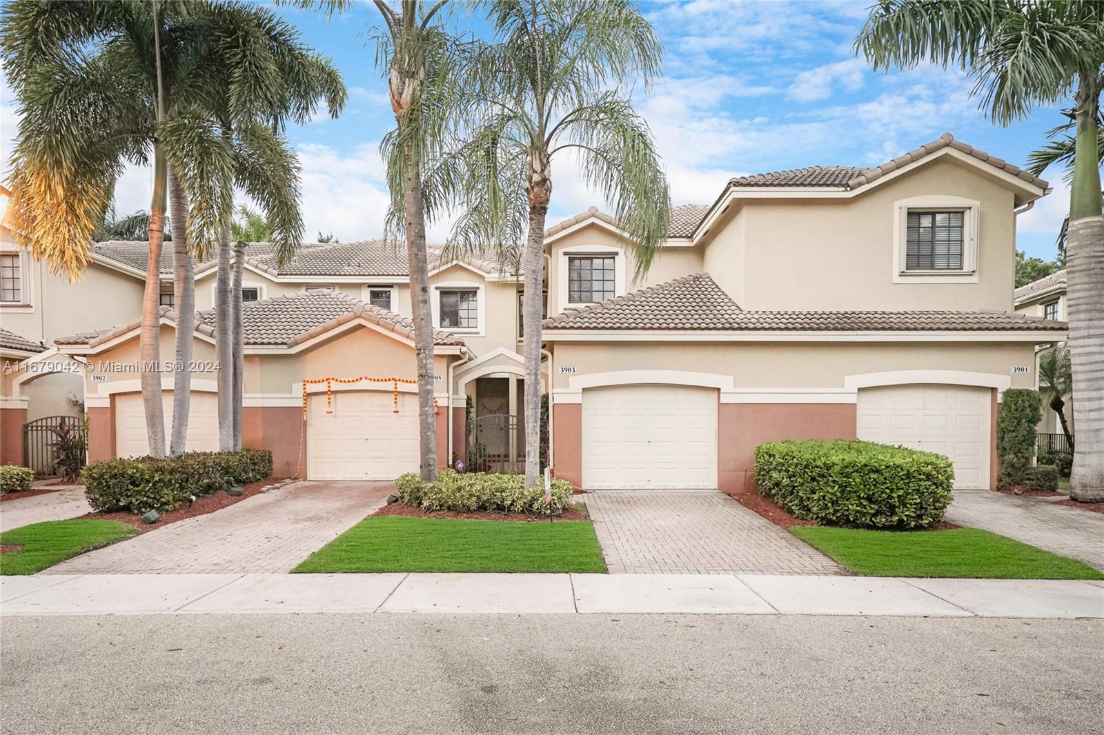 a front view of a house with a garden and palm trees