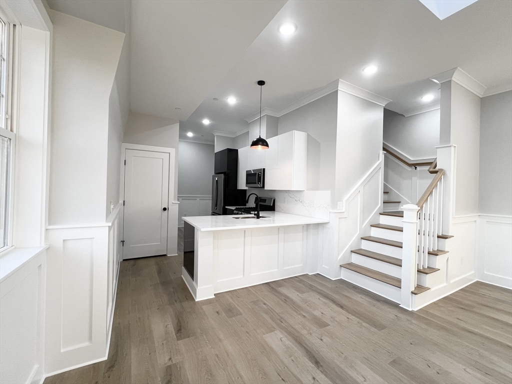 a view of kitchen with wooden floor and electronic appliances