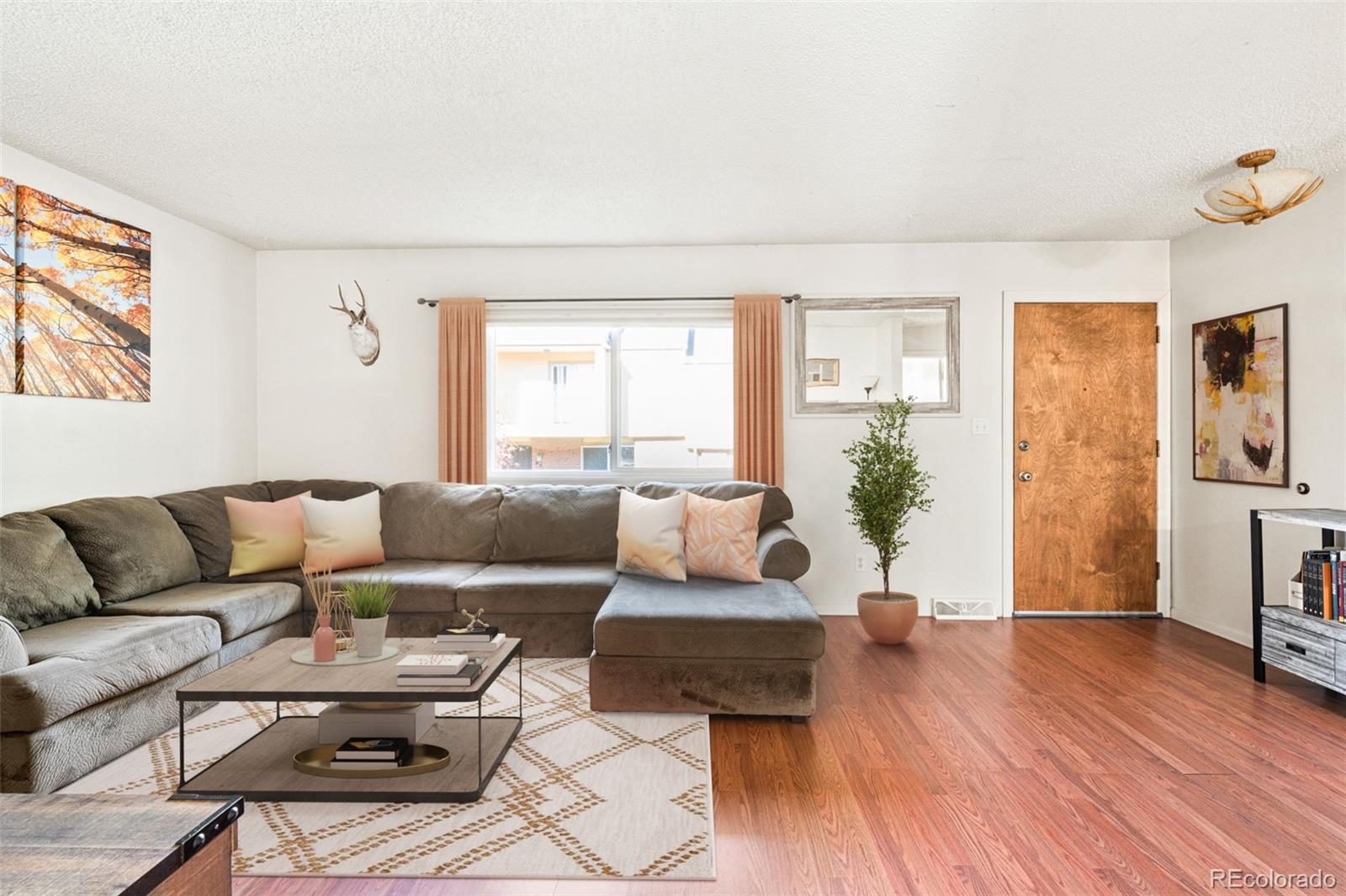 a living room with furniture and a wooden floor