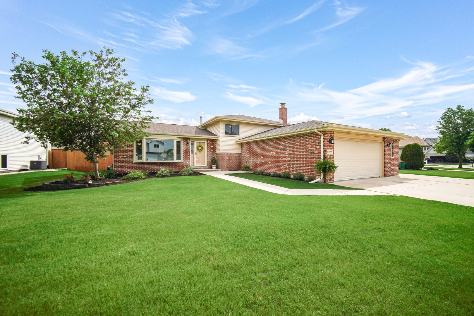 a front view of a house with a garden and yard