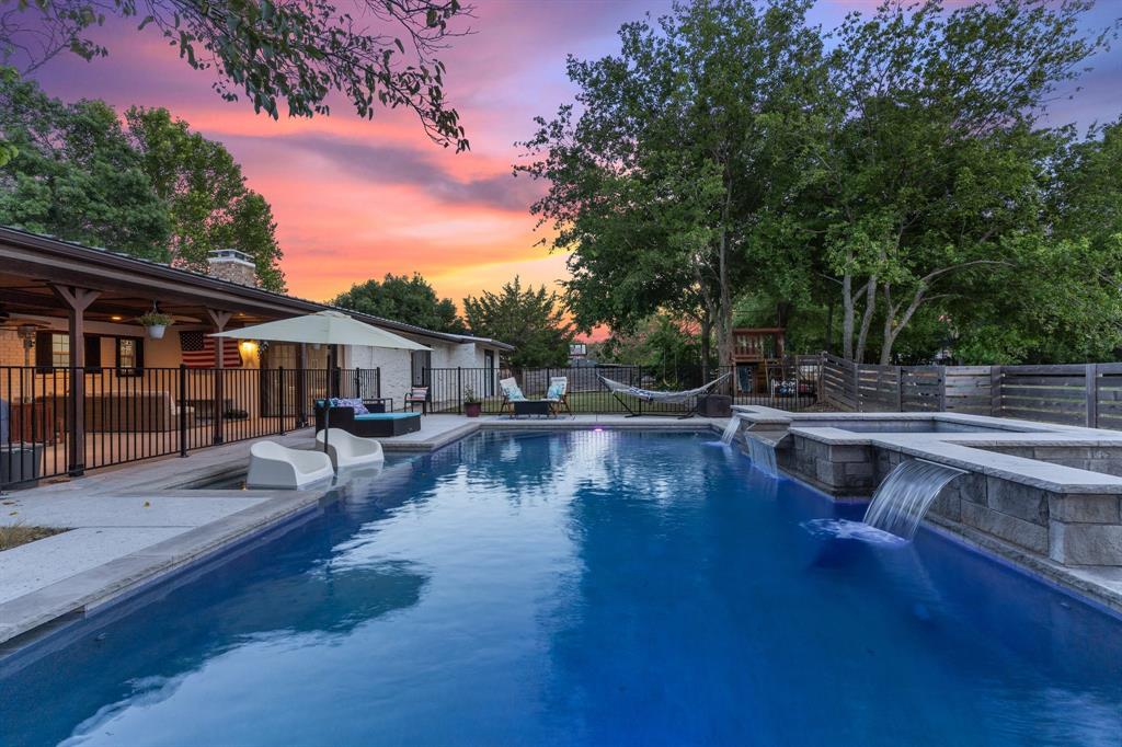 a view of swimming pool with lawn chairs and plants