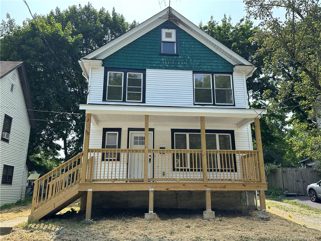 a view of a house with a deck and a yard