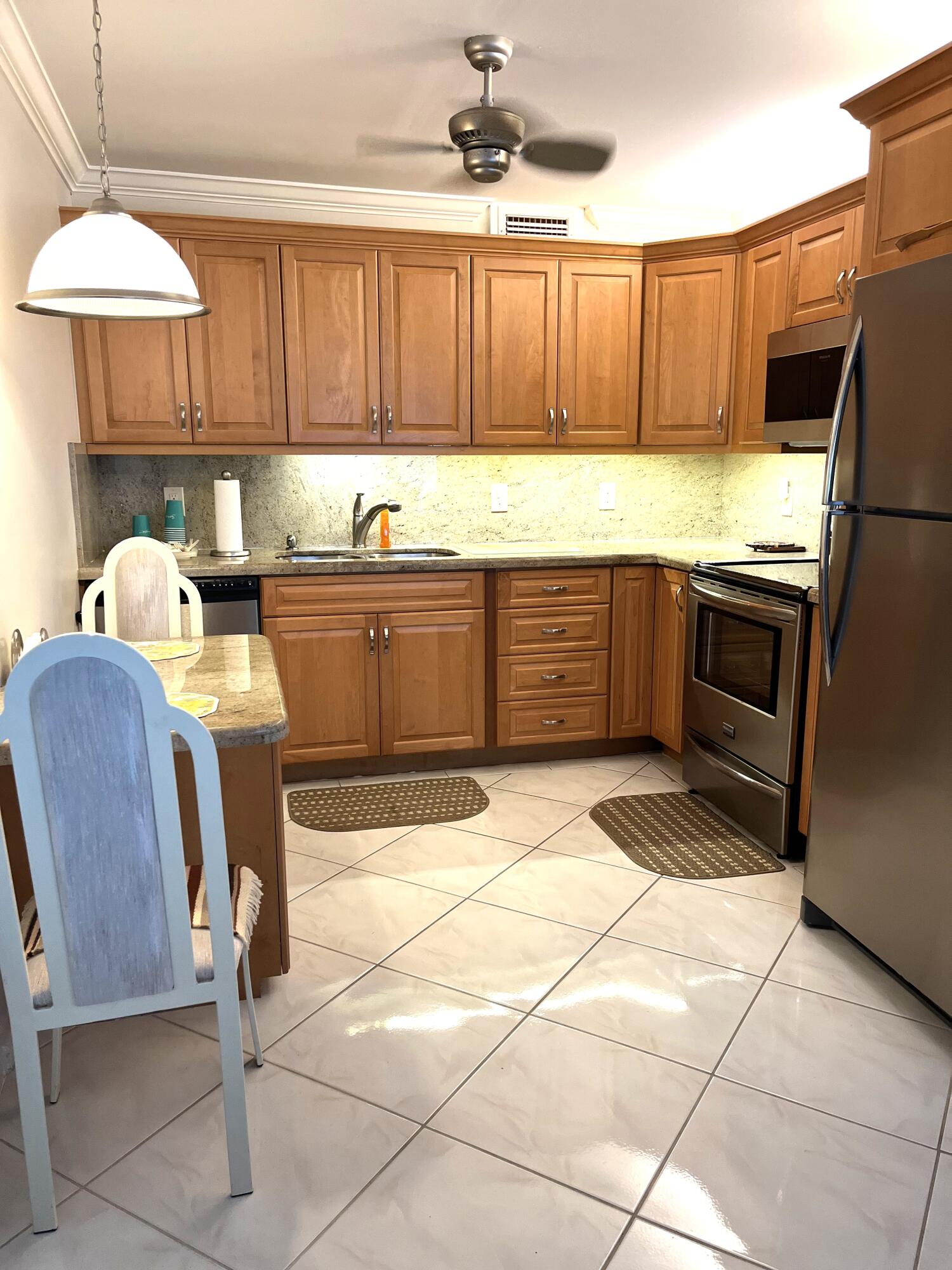 a kitchen with granite countertop a refrigerator a stove a sink and dishwasher