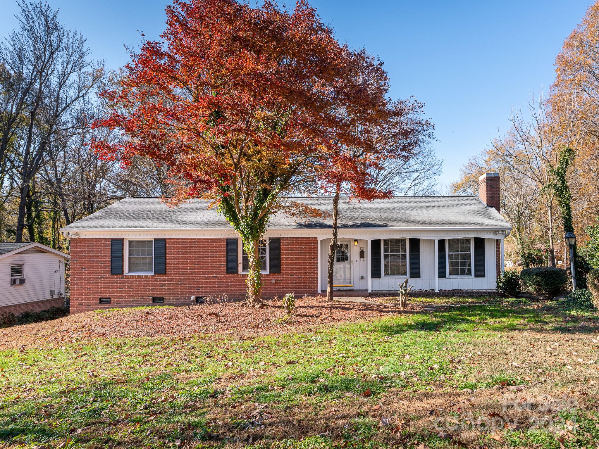 a front view of house with yard and trees around