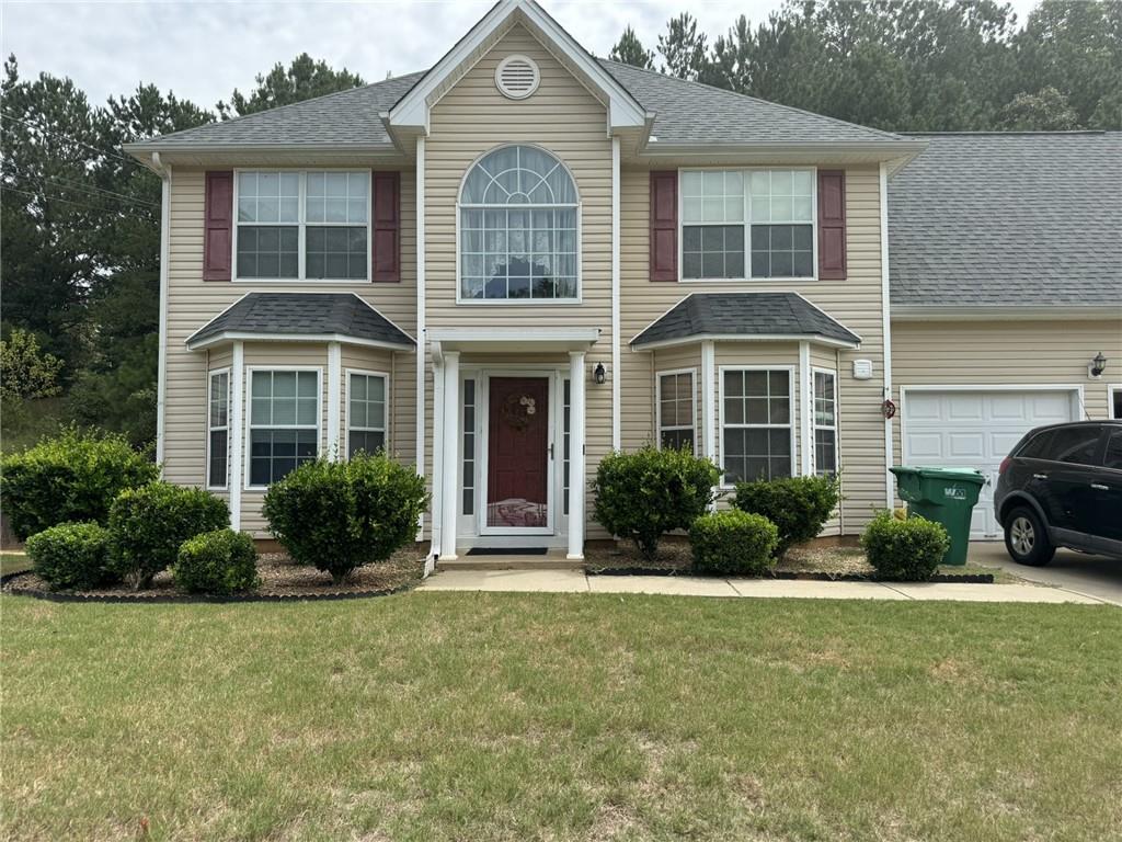 a front view of a house with porch and yard