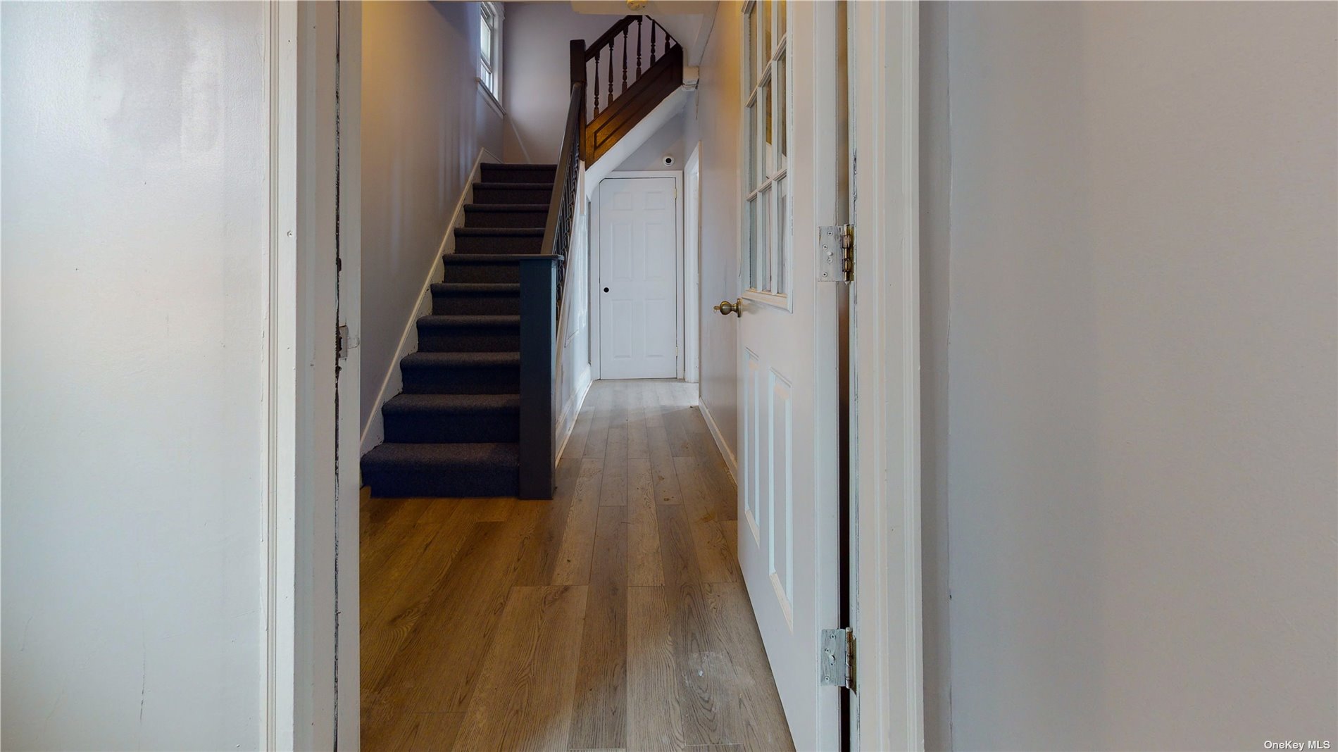 a view of a hallway with wooden floor and entryway