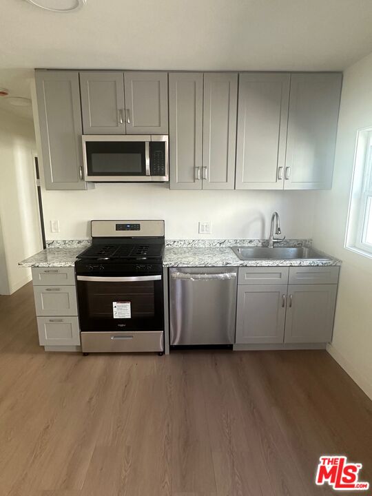 a kitchen with stainless steel appliances a stove a microwave a sink and cabinets