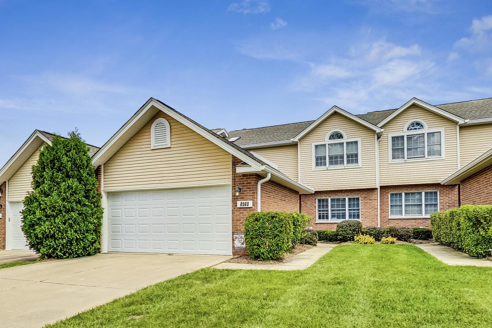 a front view of a house with a yard and garage