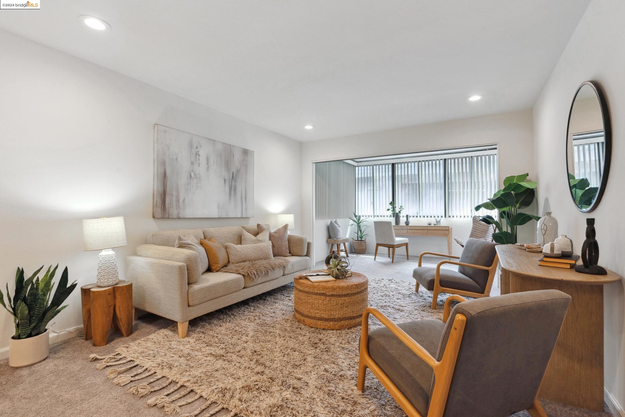 a living room with furniture potted plant and a mirror