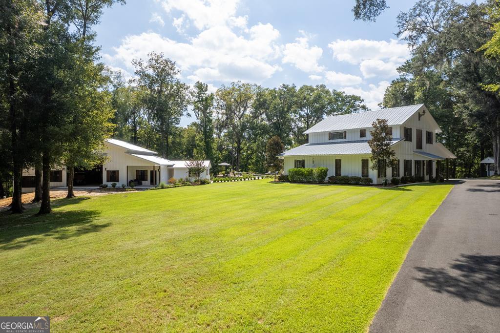 a front view of a house with a yard and swimming pool