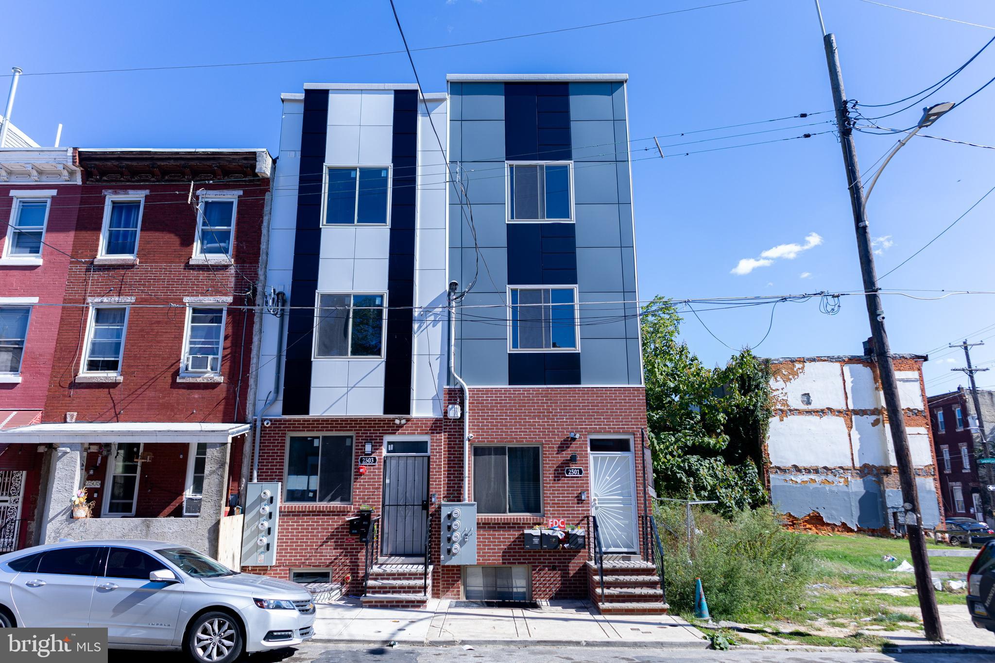 a front view of a building with glass windows and a yard