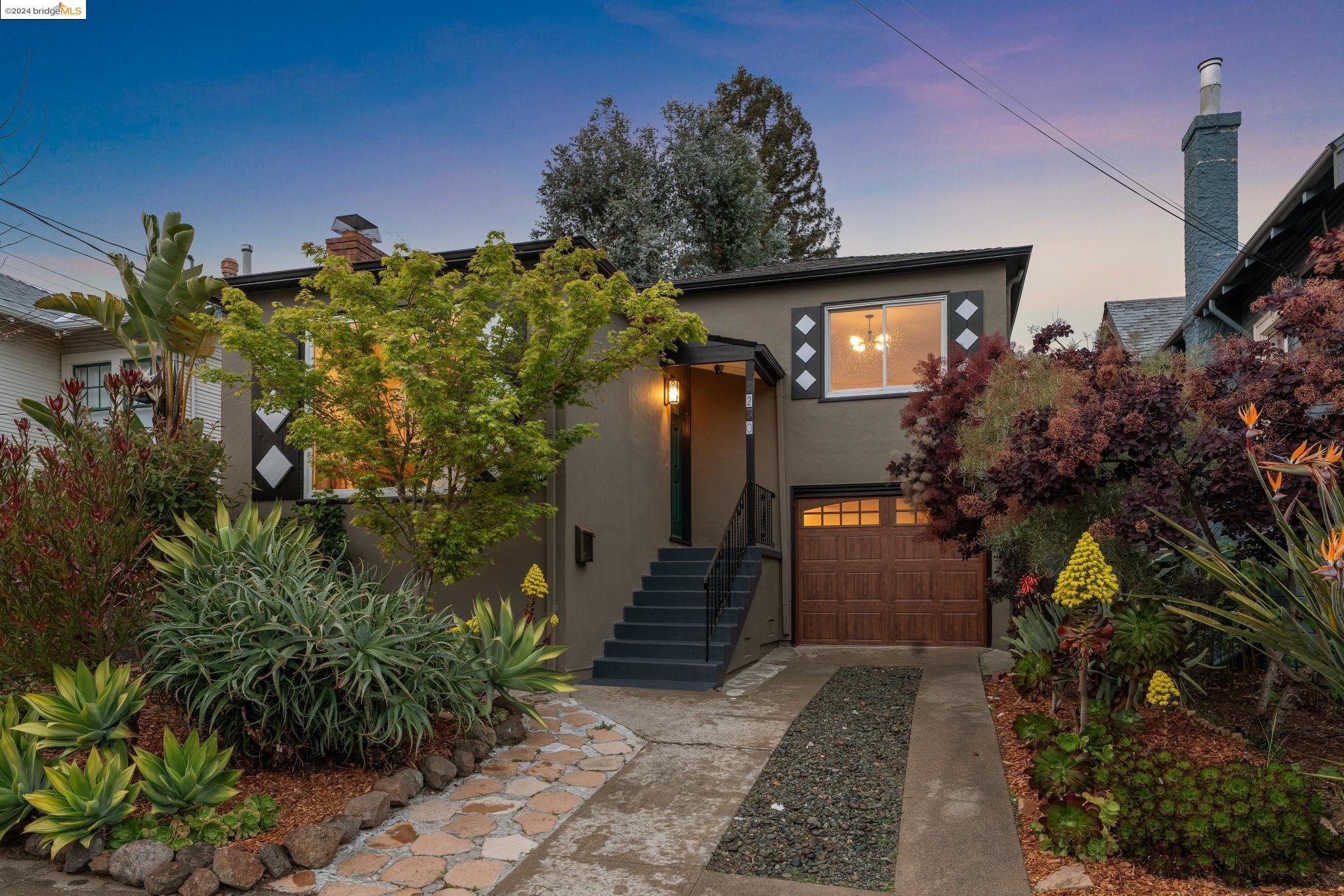 a view of a house with plants and a tree