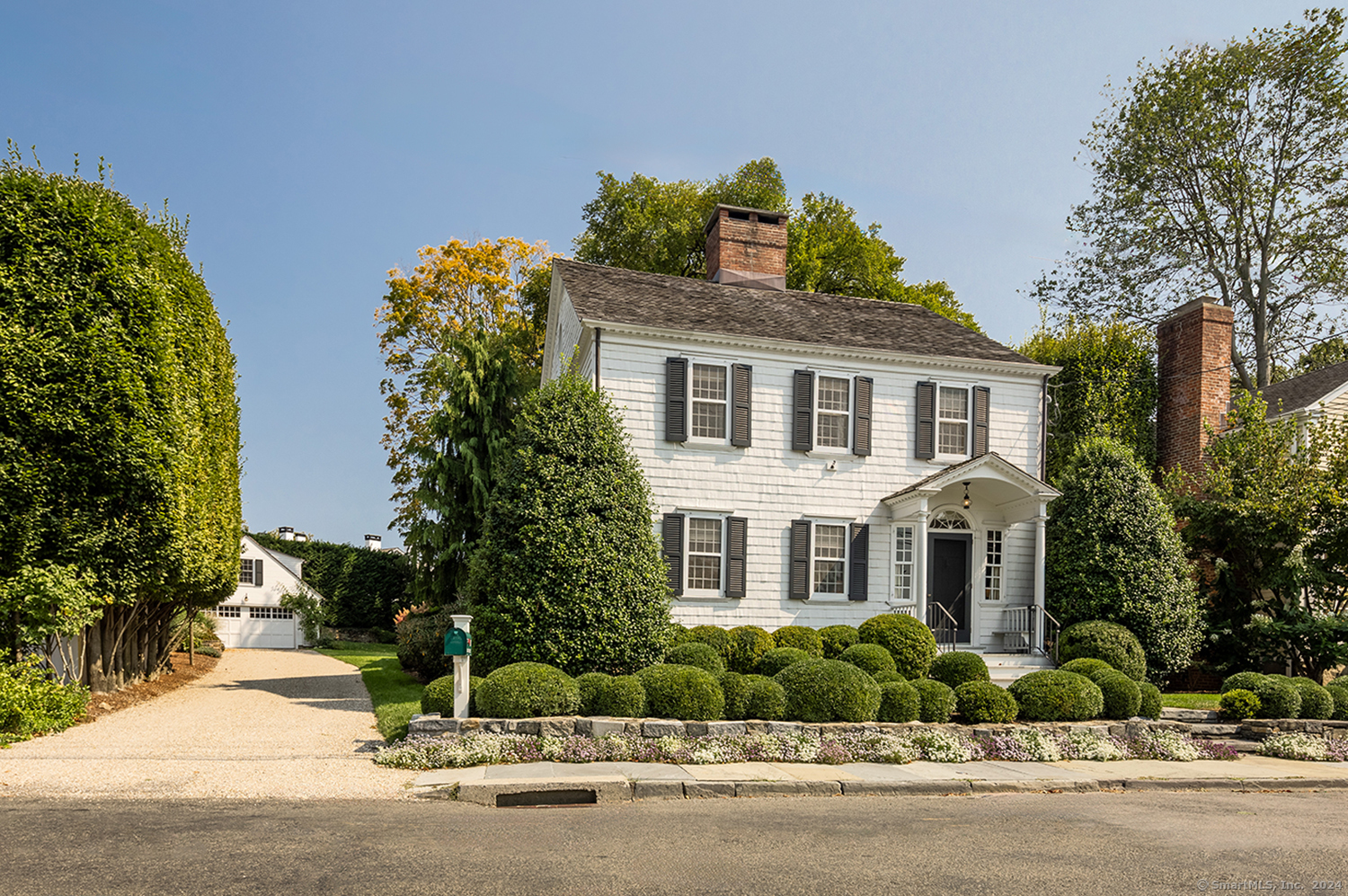 a front view of a house with a yard and potted plants