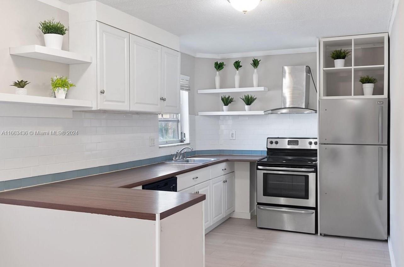 a kitchen with a sink stainless steel appliances and cabinets