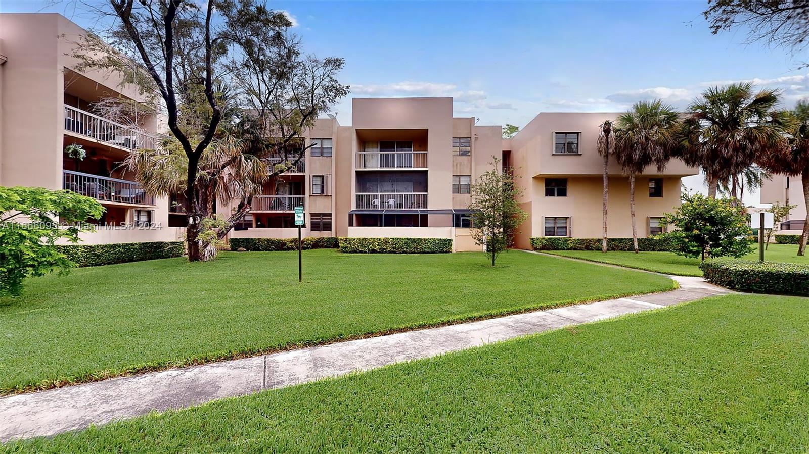 a view of a house with a big yard and large trees