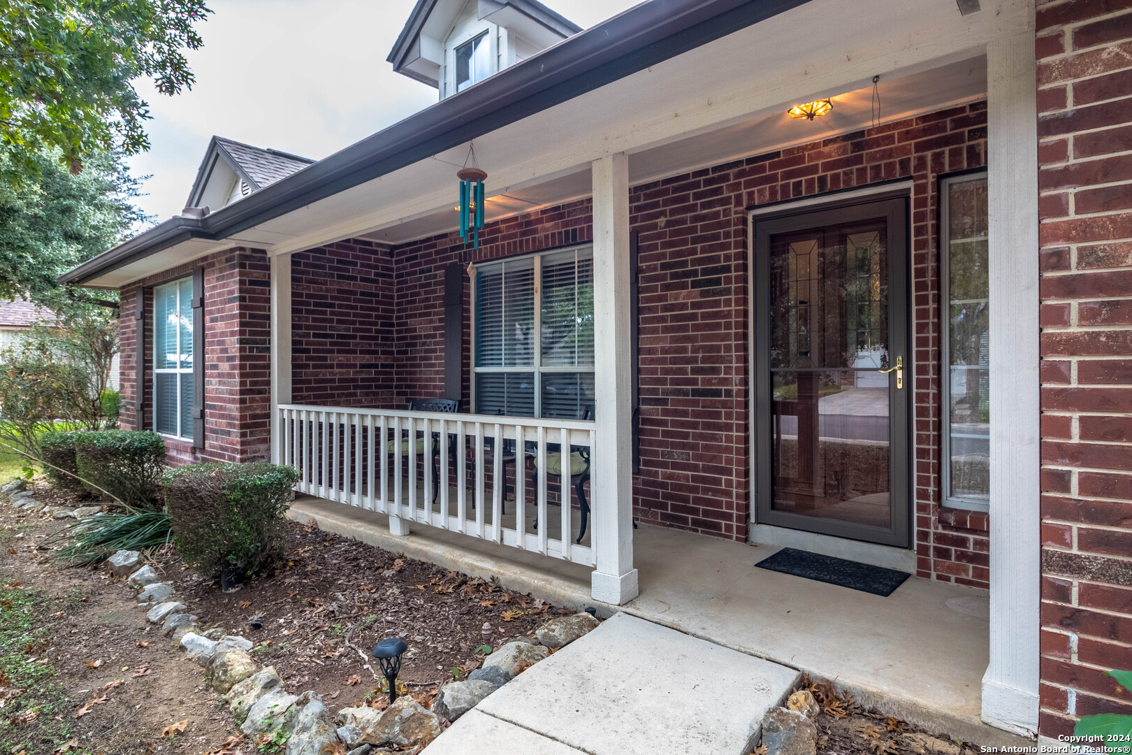 a porch with a bench next to a yard