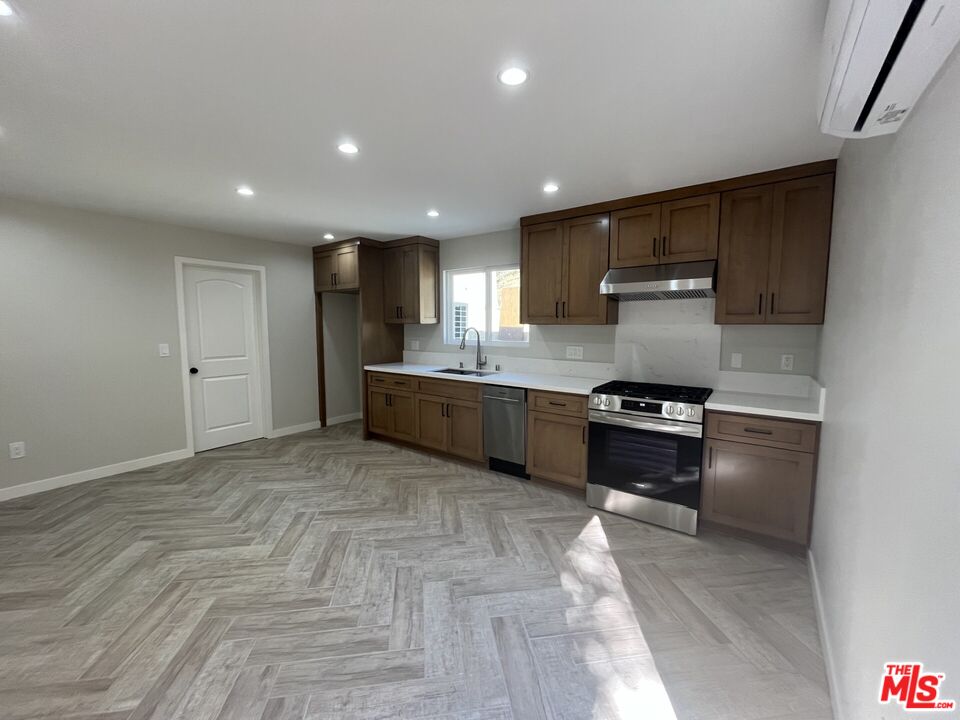 a kitchen with stainless steel appliances granite countertop a stove a sink and a refrigerator