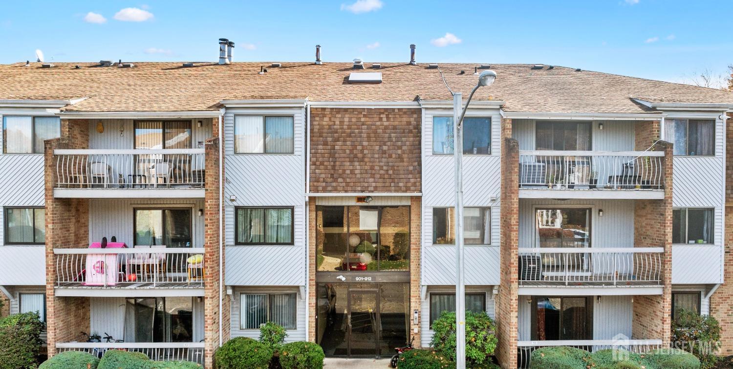 a front view of a residential apartment building with a yard