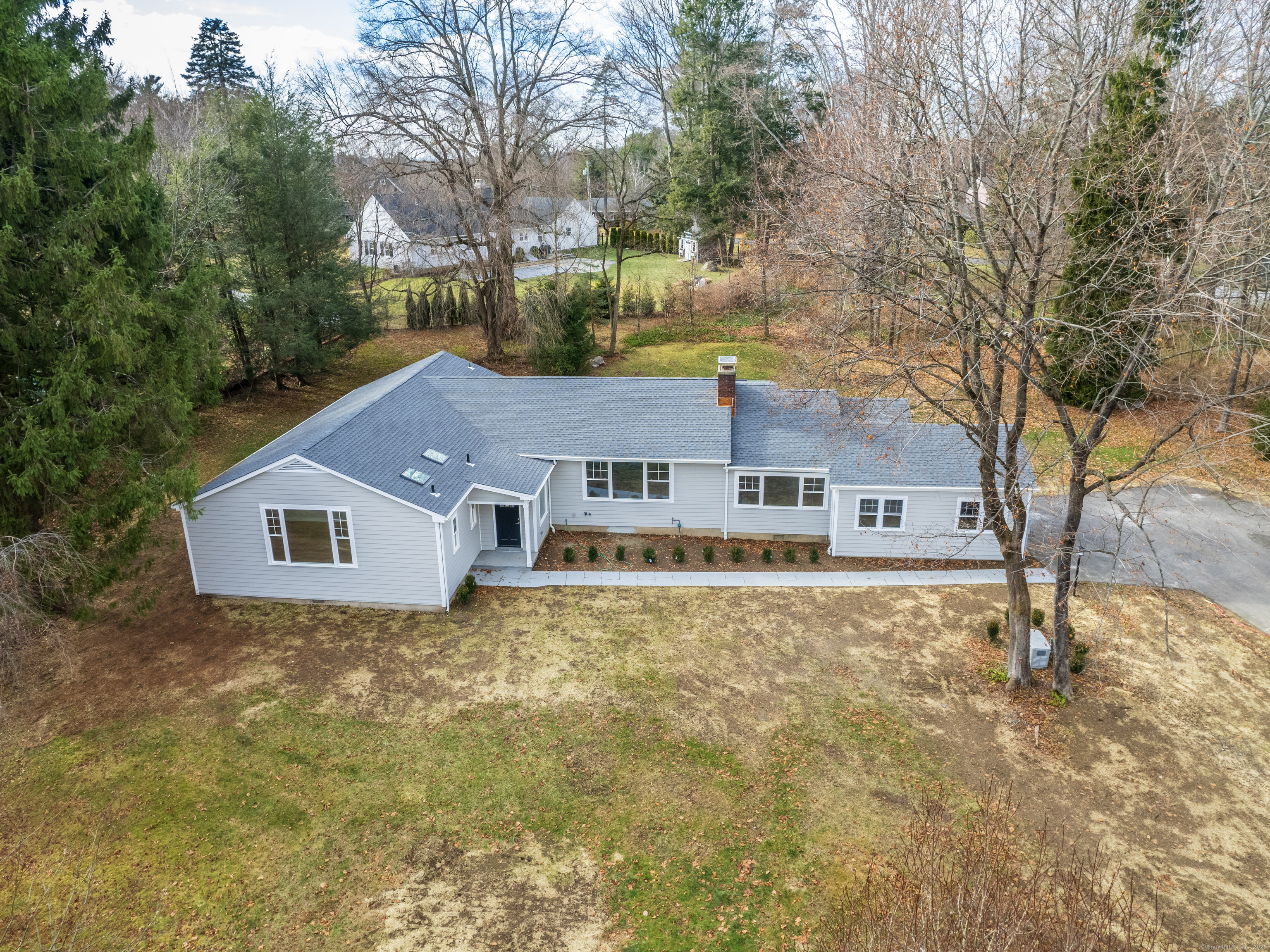 a front view of house with yard and trees in the background