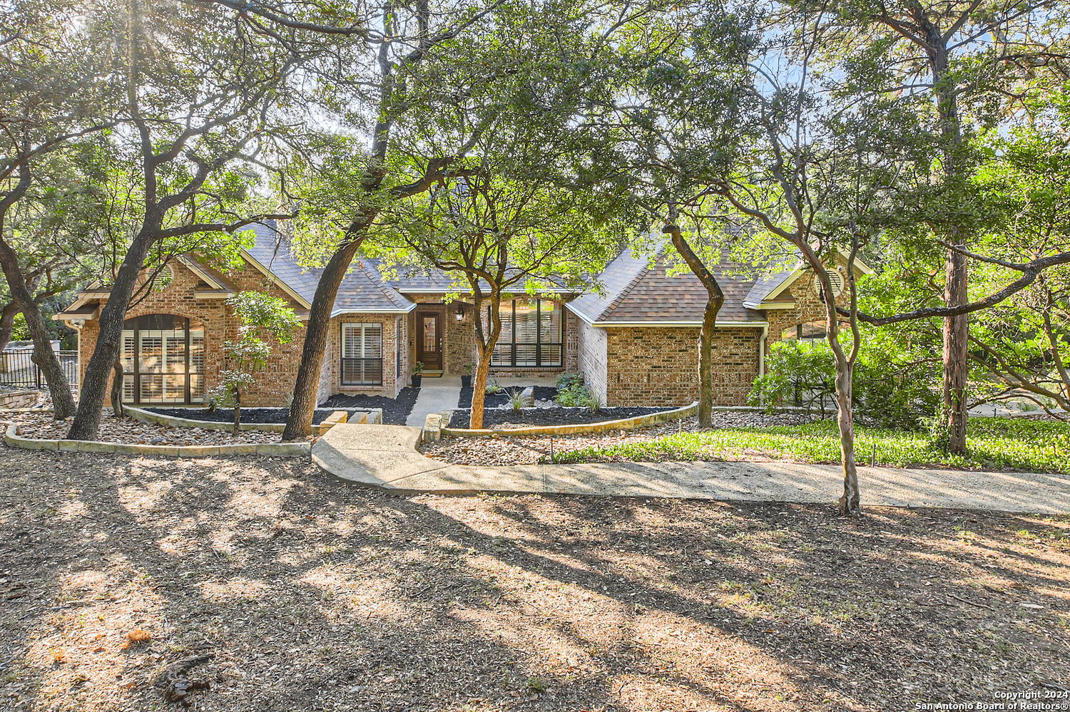 a view of a house with a yard and large tree