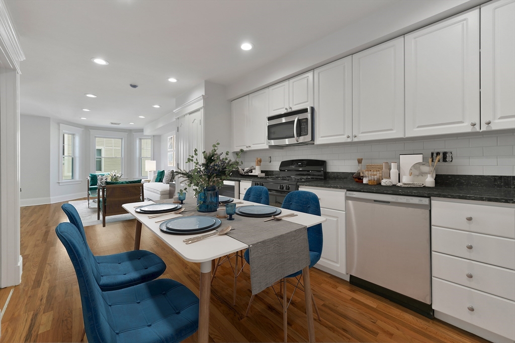 a kitchen with a dining table chairs and white cabinets