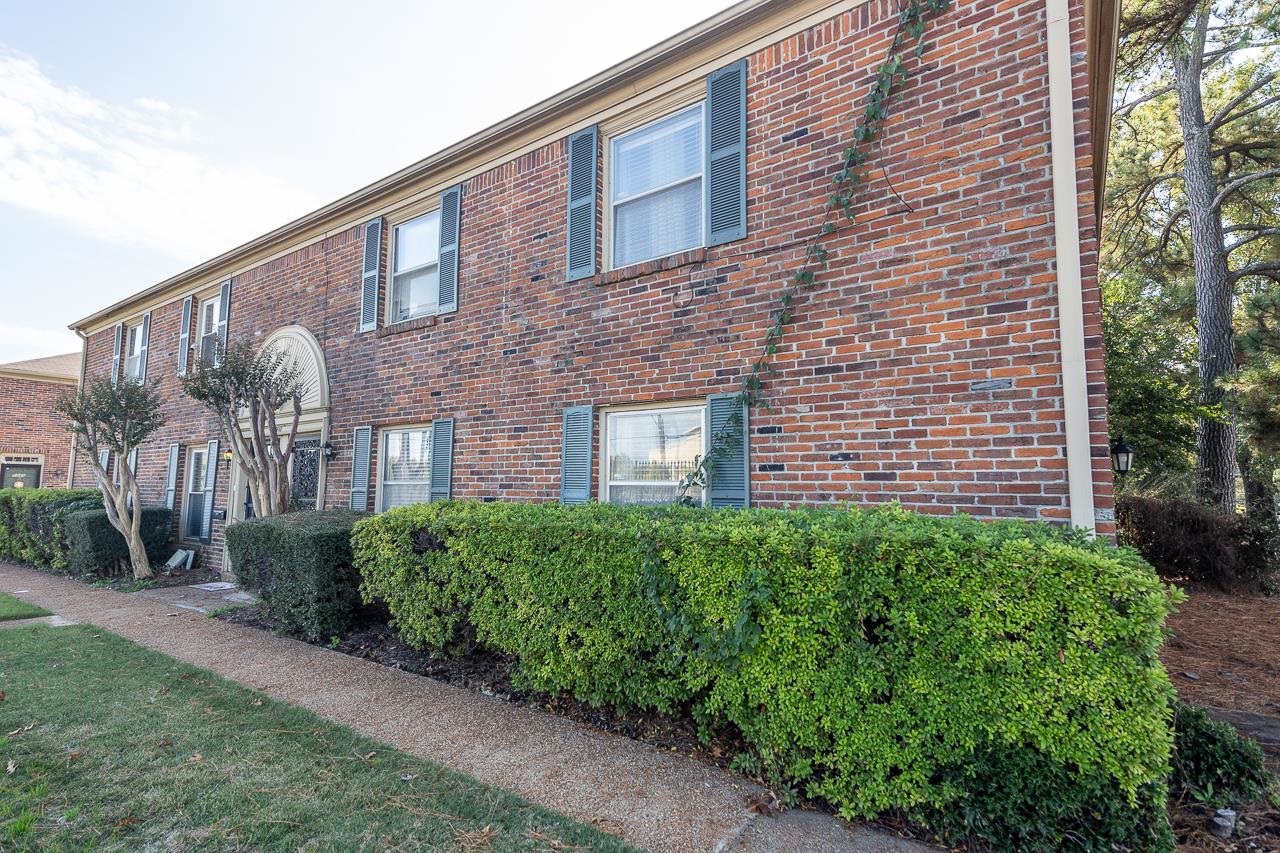 a view of a brick building next to a yard