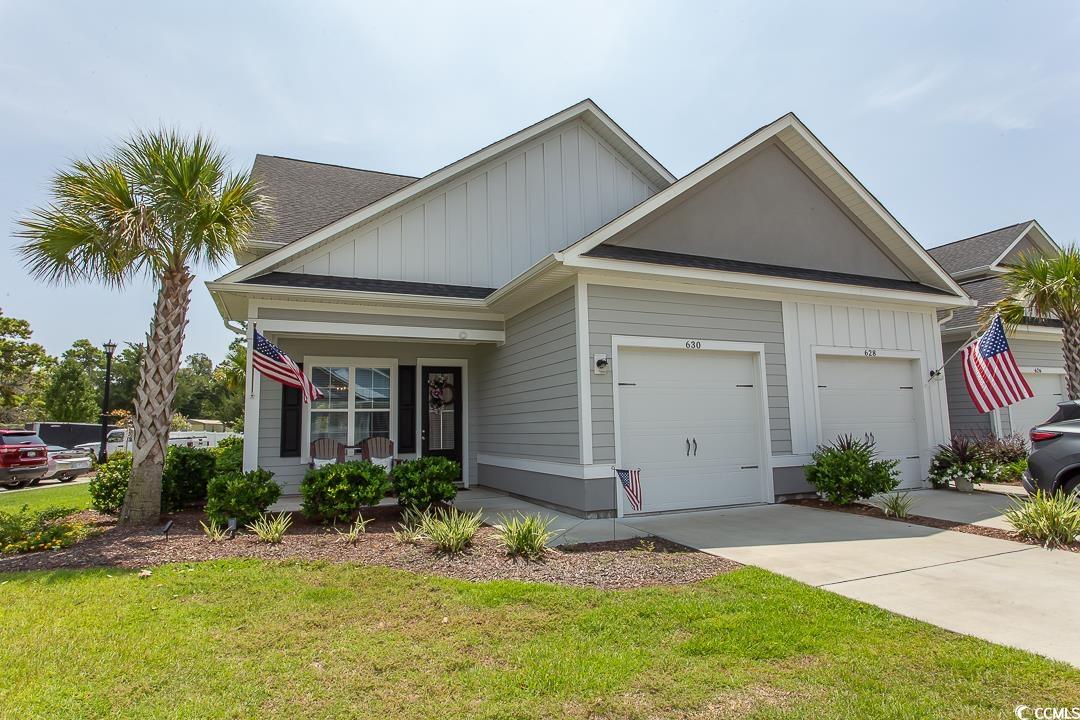 View of front of home featuring a porch, a front y