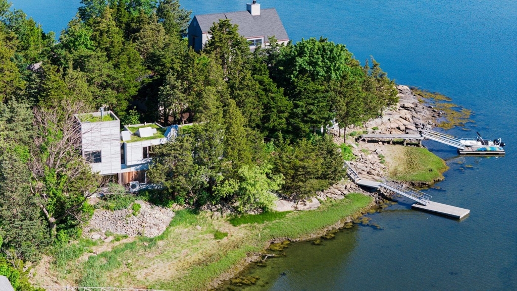 an aerial view of a house with a yard lake and outdoor seating