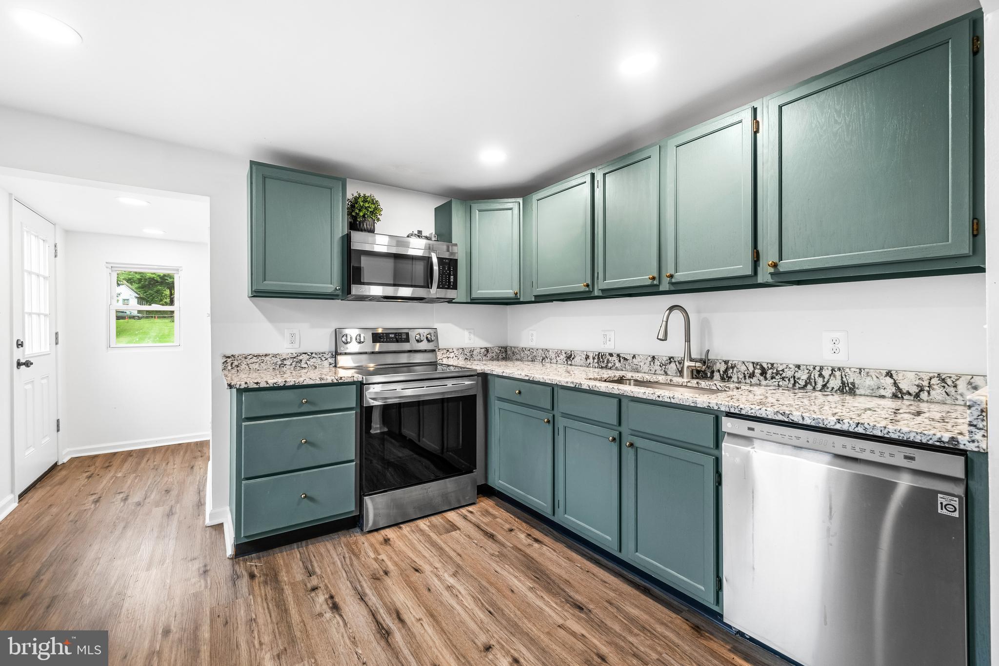 a kitchen with granite countertop a sink and cabinets