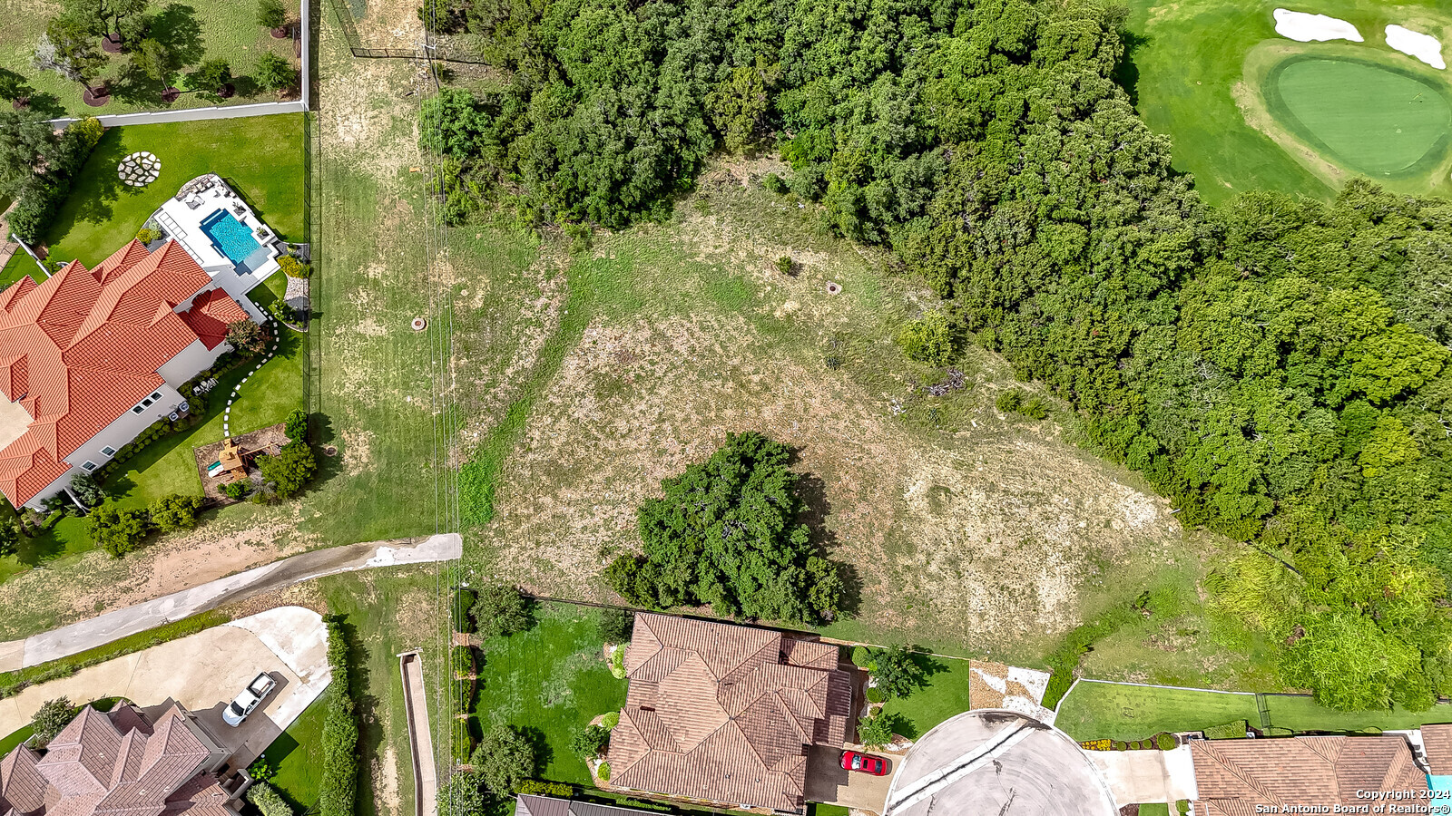 an aerial view of a house with a yard basket ball court and outdoor seating