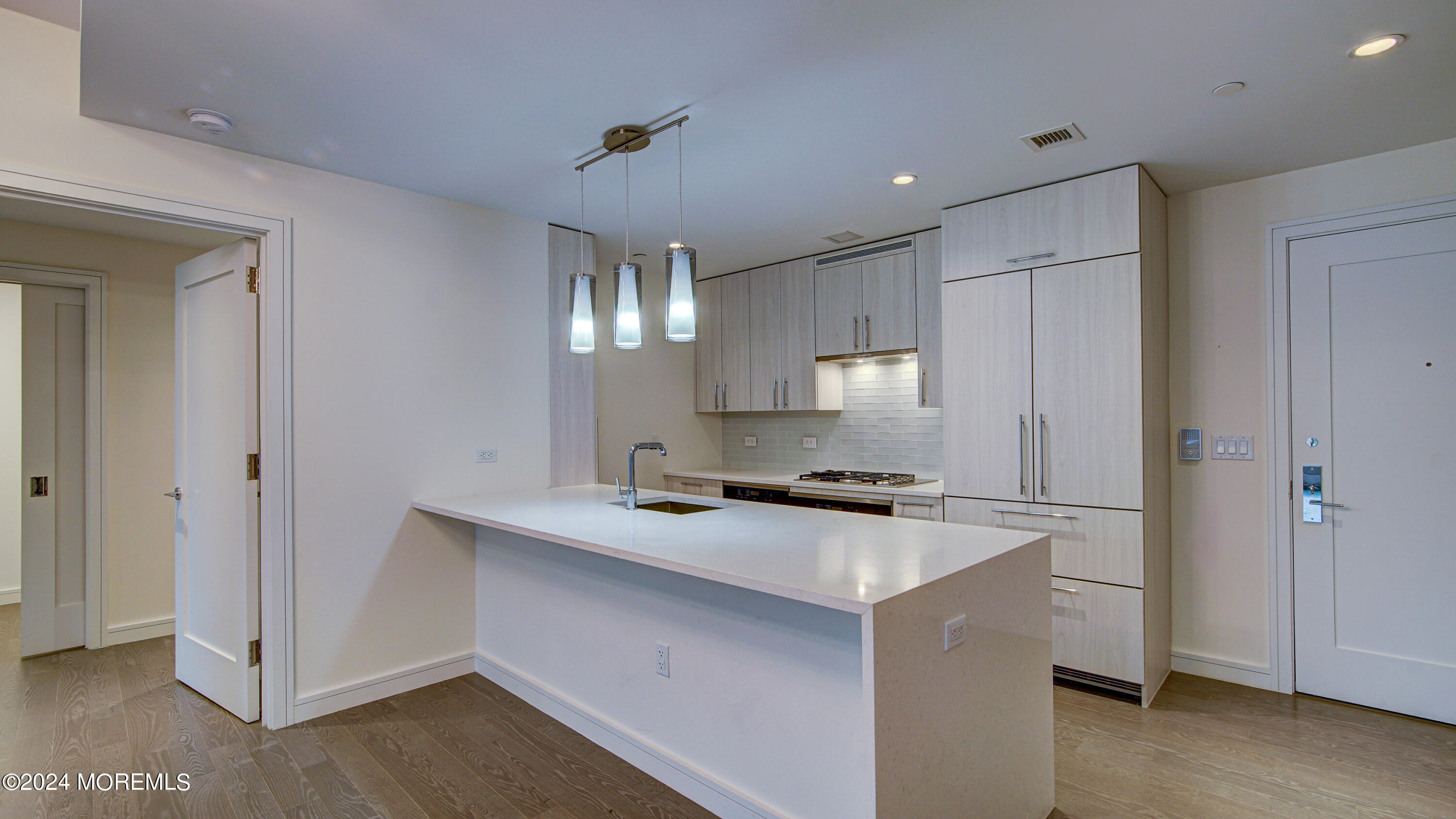 a kitchen that has a sink a stove and cabinets