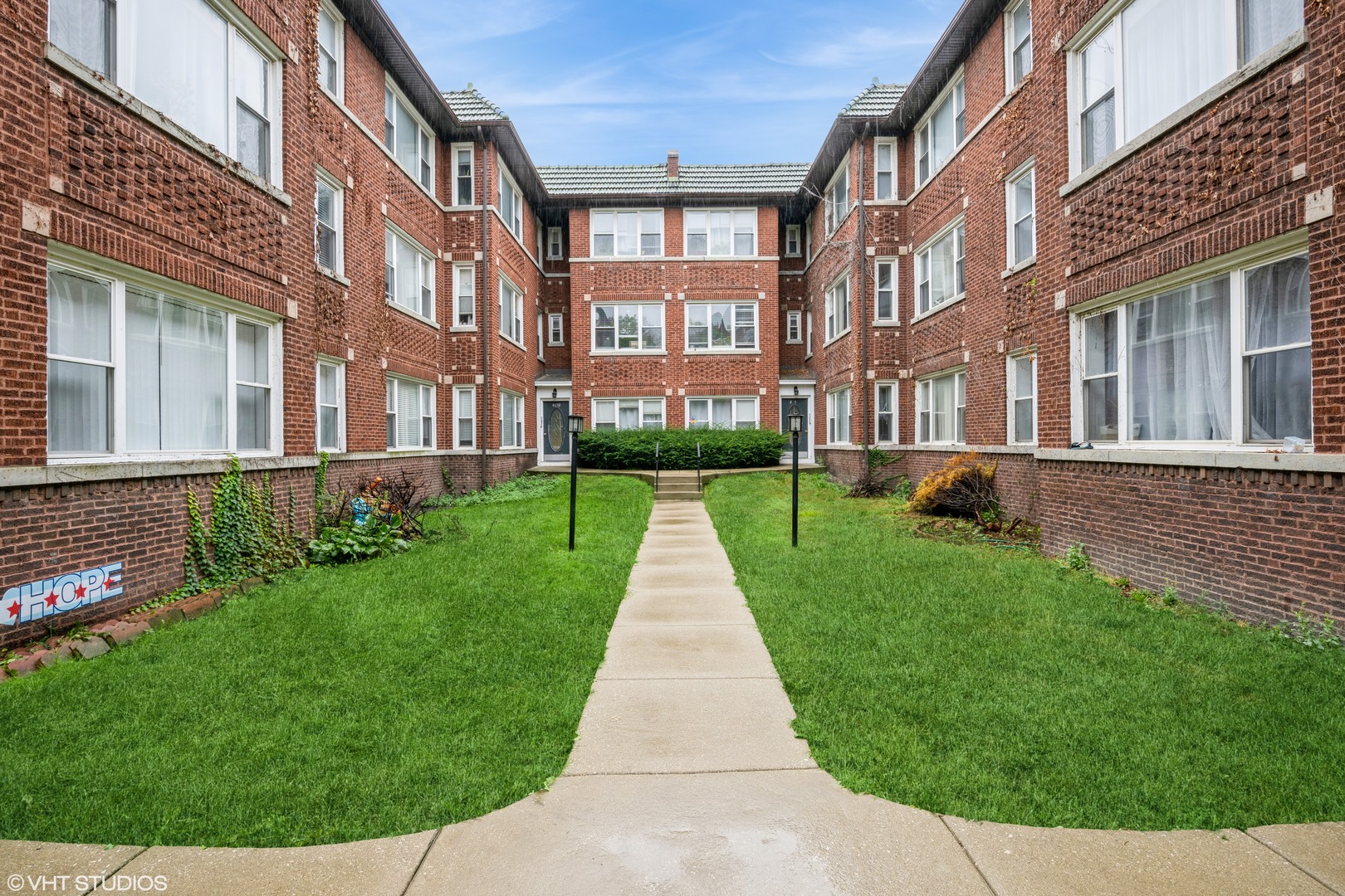 a view of a brick building next to a big yard