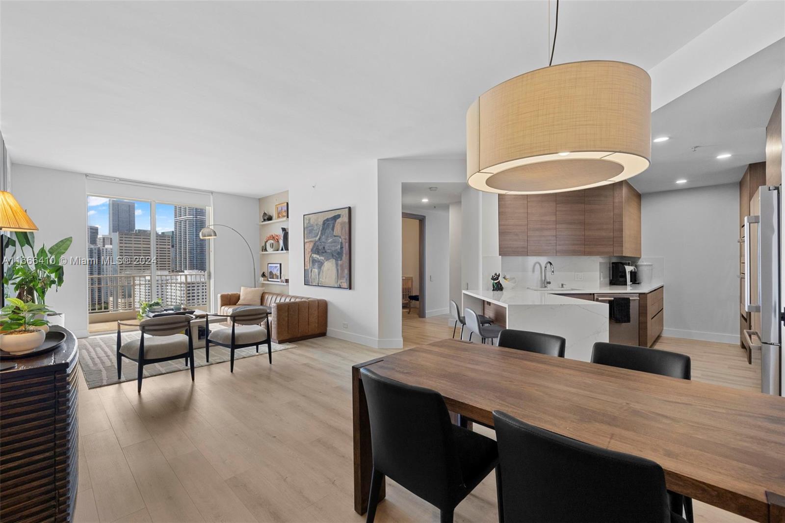 a living room with furniture kitchen view and a large window