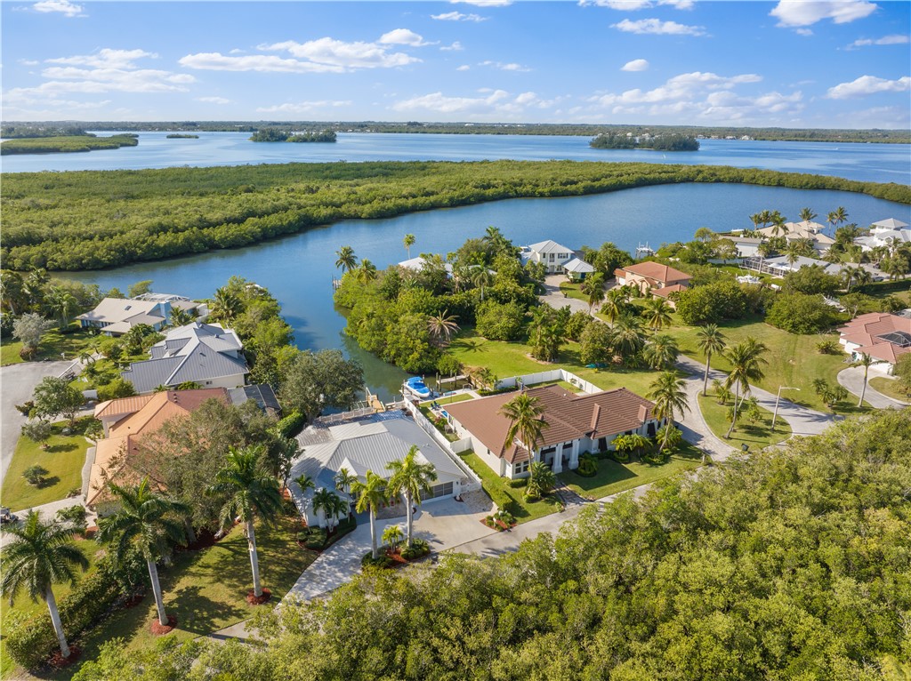 an aerial view of residential houses with outdoor space and lake view