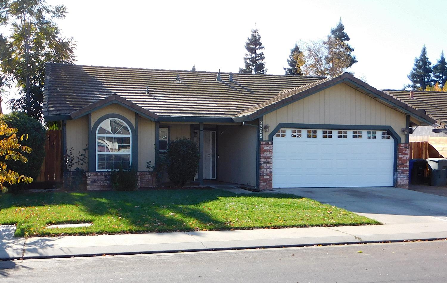 a front view of a house with a garden and yard