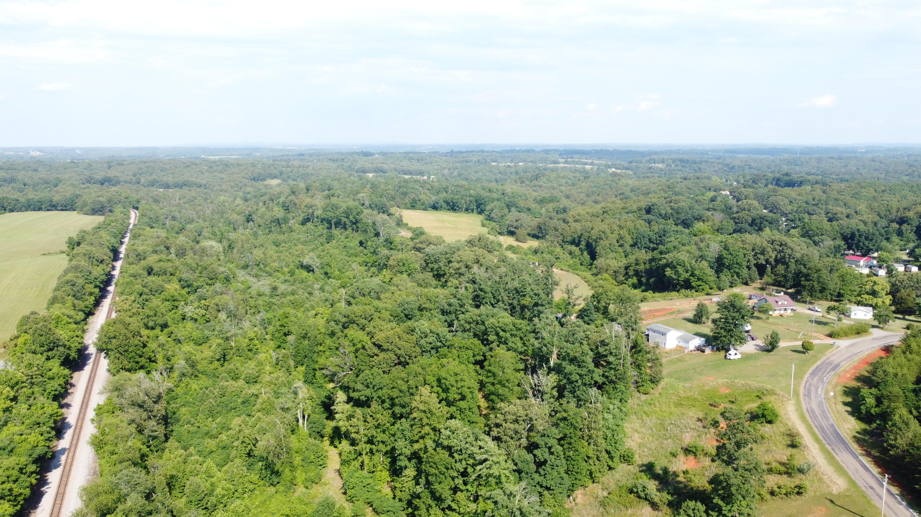 an aerial view of residential houses with outdoor space and trees