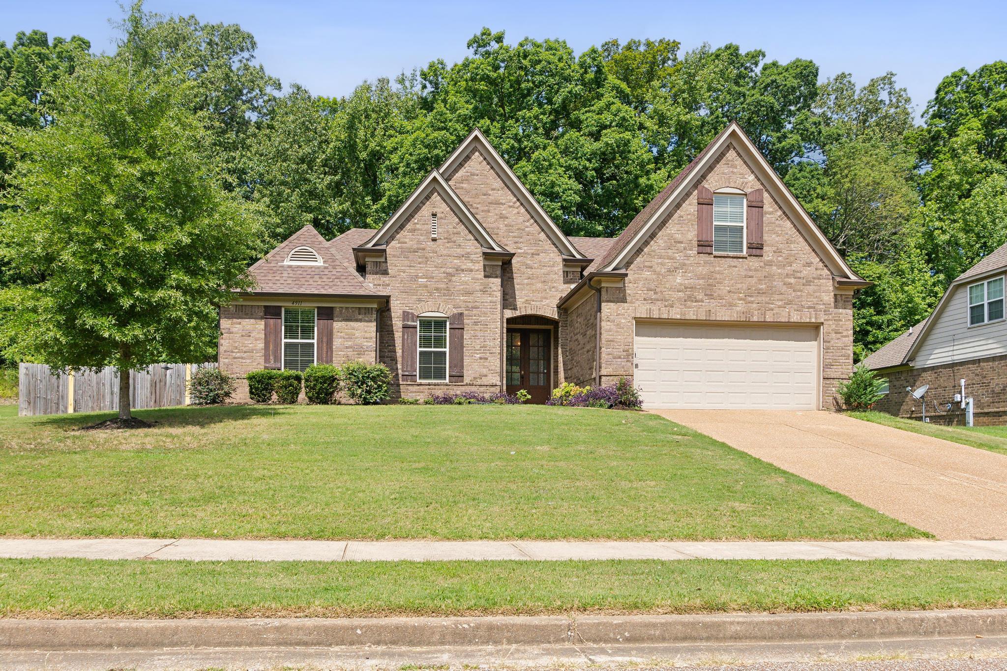 View of front of house with a garage and a front lawn