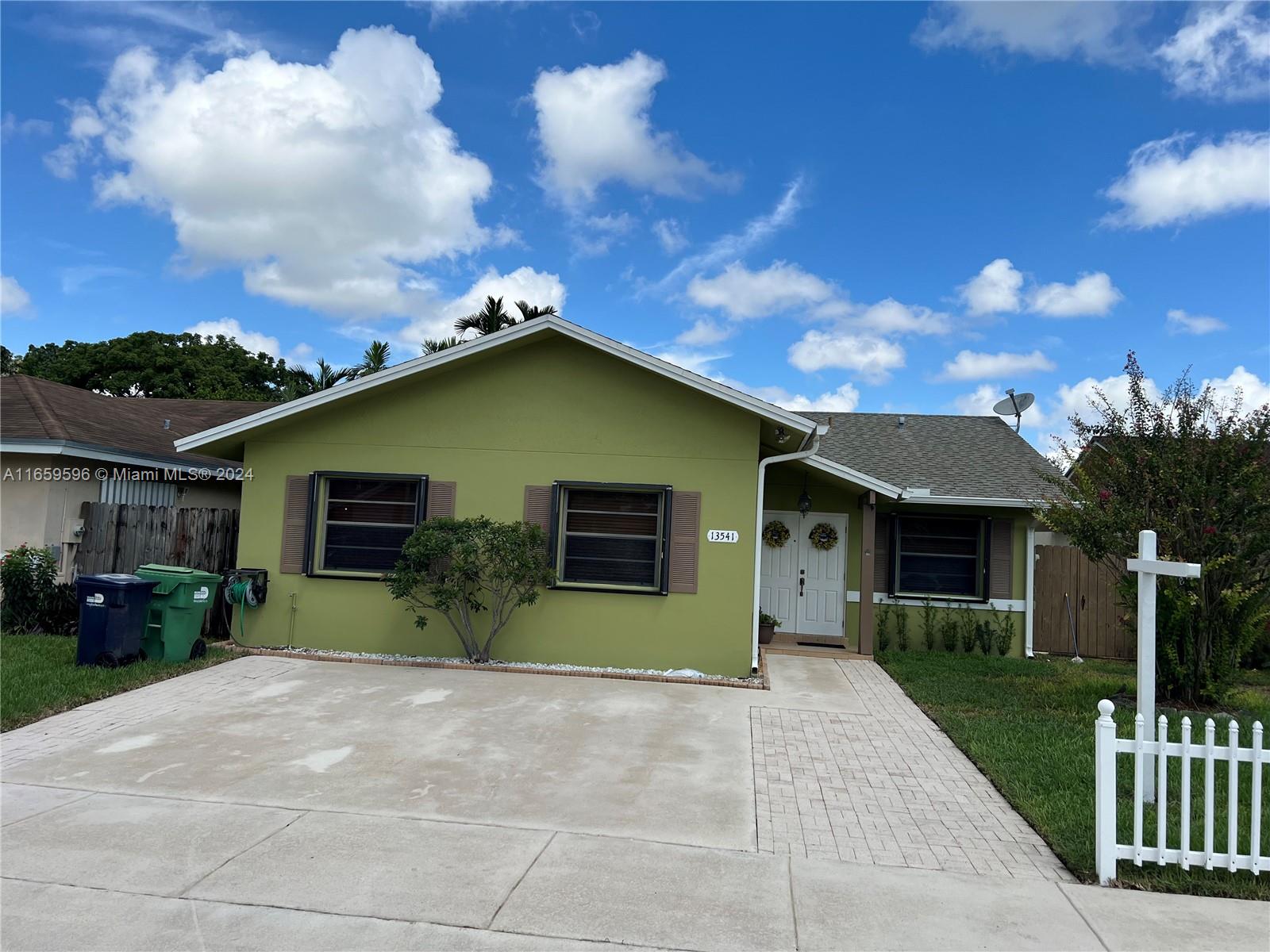 a view of a house with backyard and trees