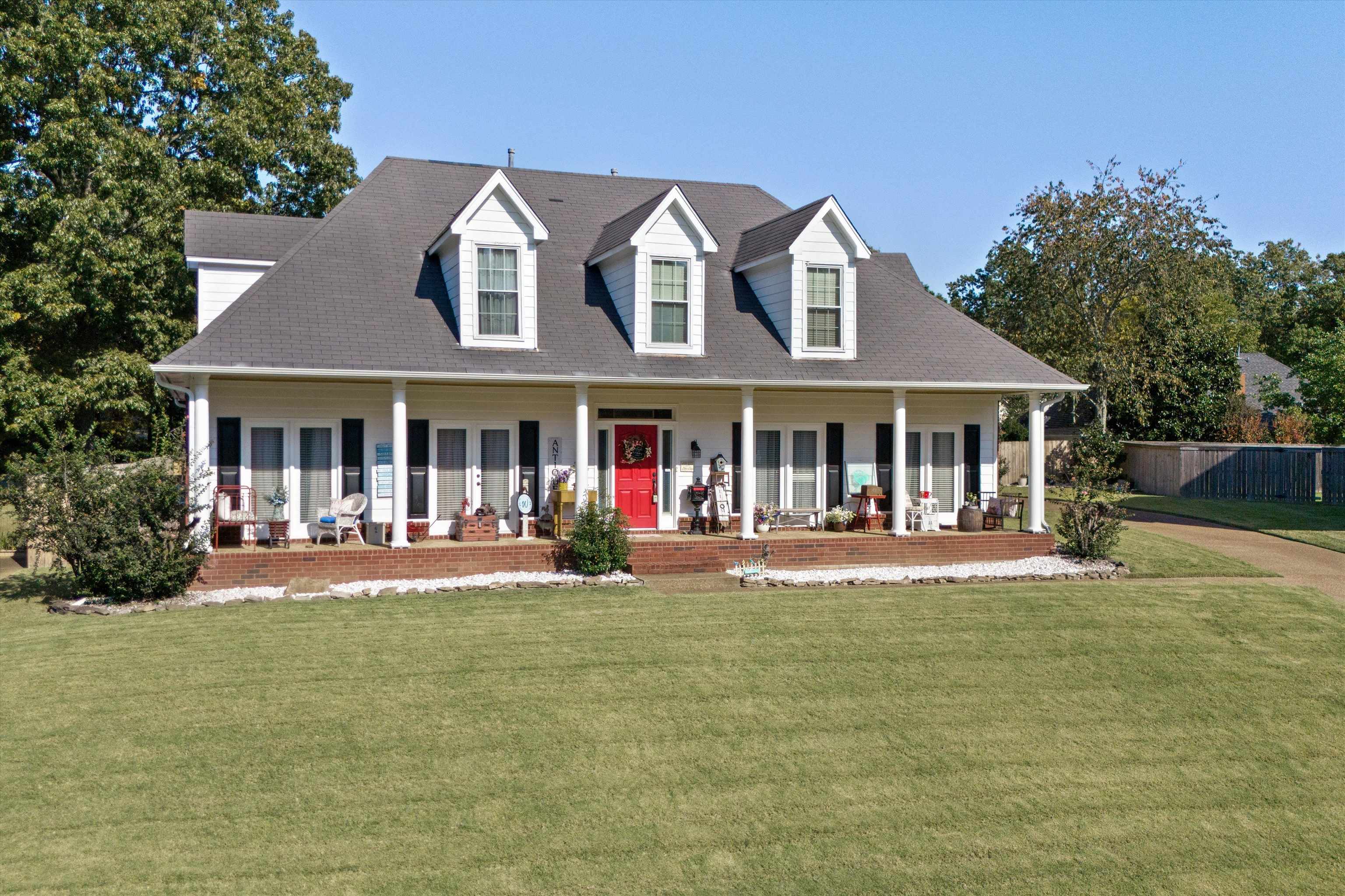 Cape cod-style house with a front yard and a porch