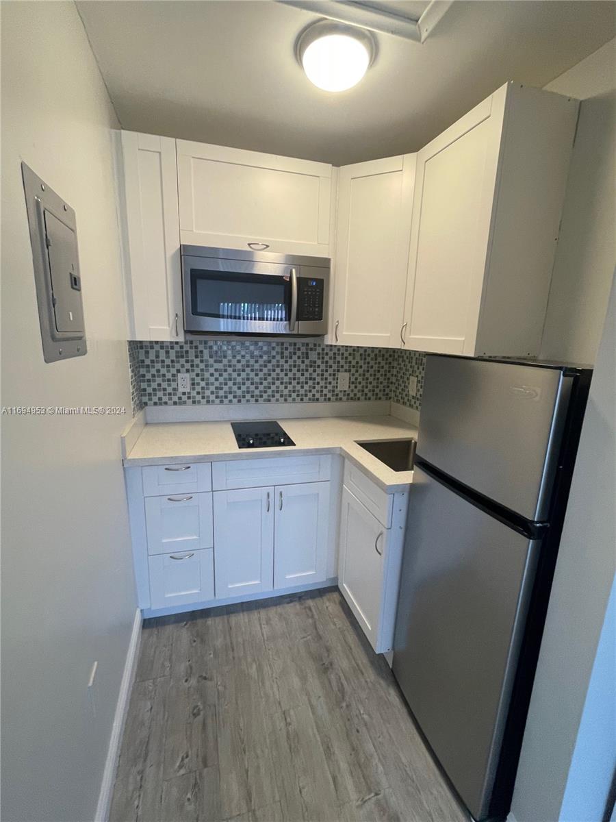 a kitchen with granite countertop a stove a microwave and a sink