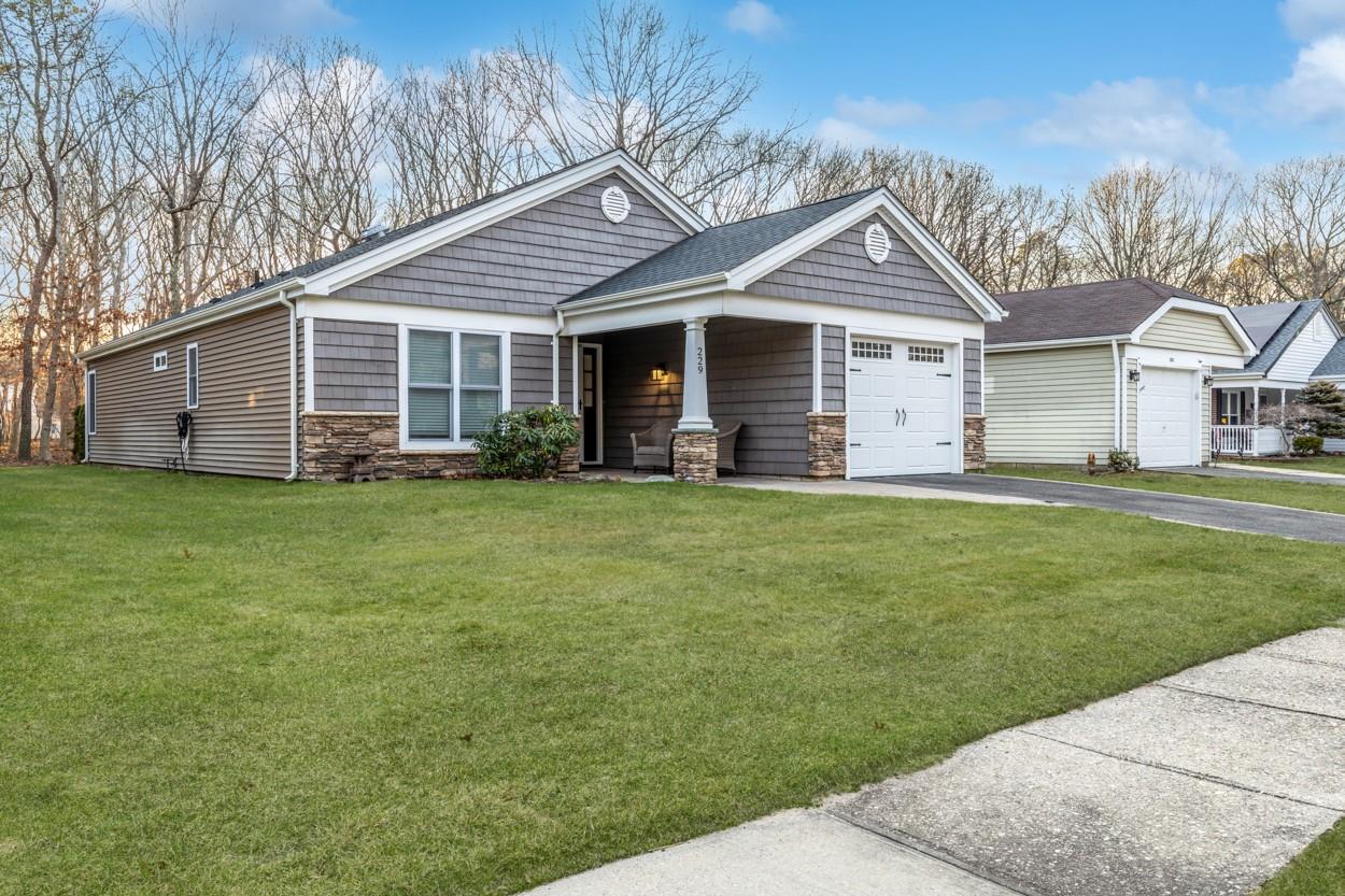 View of front of property with a front yard and a garage